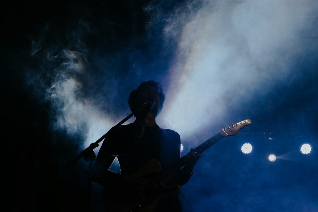 Uruguayan musician singing on stage under colorful concert lights